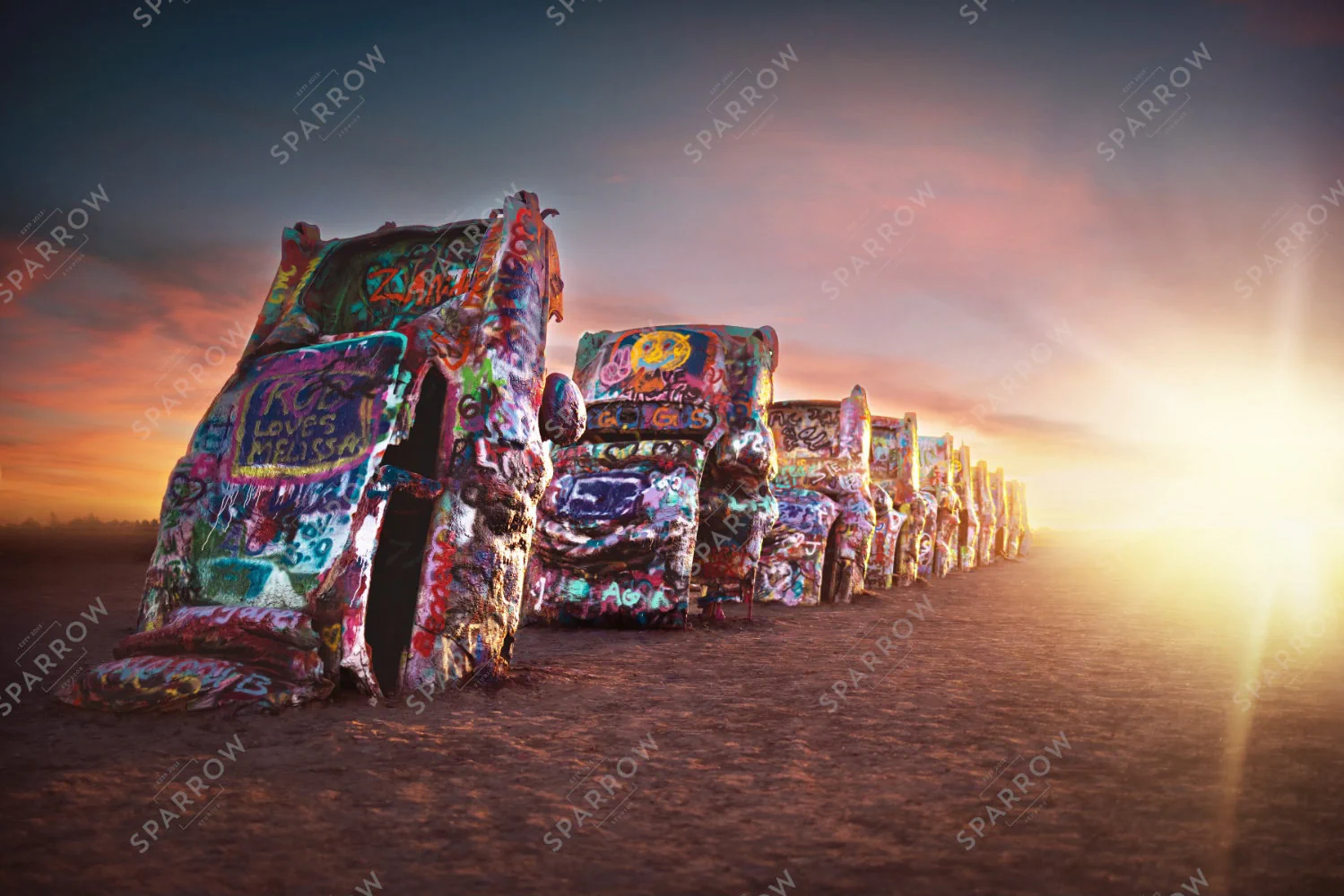 Dawn of Legends, colorful Cadillacs silhouetted at sunrise at Cadillac Ranch.